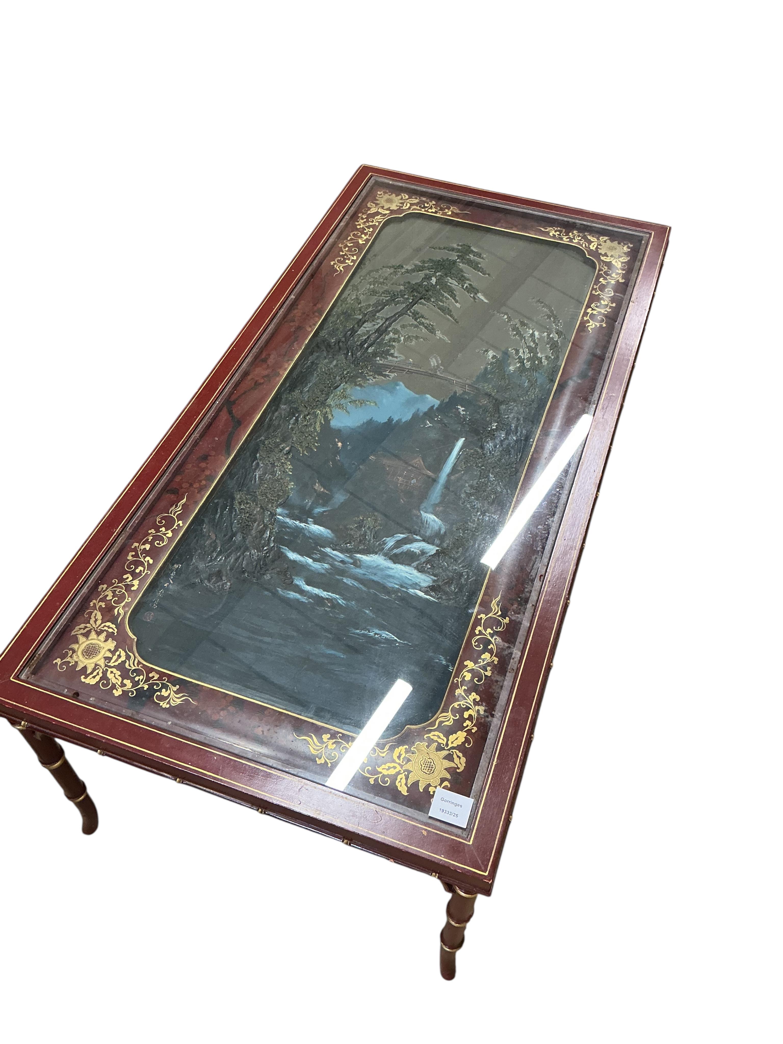 A Contemporary painted scarlet lacquer rectangular occasional table, decorated with a waterfall landscape on faux bamboo legs, width 122cm, depth 60cm, height 45cm